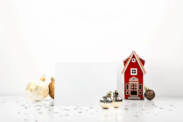 Weiße leere Weihnachtskarte auf hellem Weihnachtshintergrund mit Dekorationen. Minimalistische Postkarten-Attrappe — Stockfoto