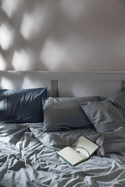 Diário aberto para escrever na cama com têxteis azuis ao luar. Rituais noturnos para a saúde mental. — Fotografia de Stock