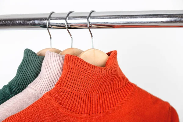 Temel sonbahar kadınlarının gardırop konsepti. Boş balıkçı yaka kazaklar elbise askısında. Parlak turuncu, yuvarlak yakalı, bej ve yeşil.. — Stok fotoğraf