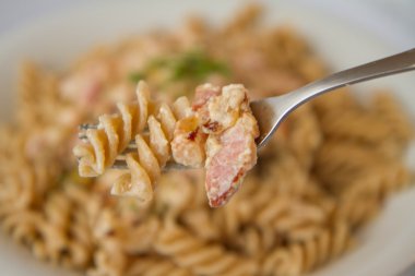 Düdük makarna krema ve domuz pastırması sos ile tere ile dekore edilmiştir.