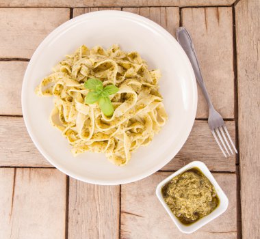 Ahşap arka plan üzerinde Fesleğenli tagliatelle pesto ile dekore edilmiş
