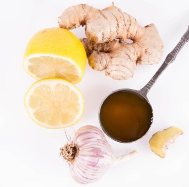 Beyaz arka planda bal, limon, zencefil ve sarımsak