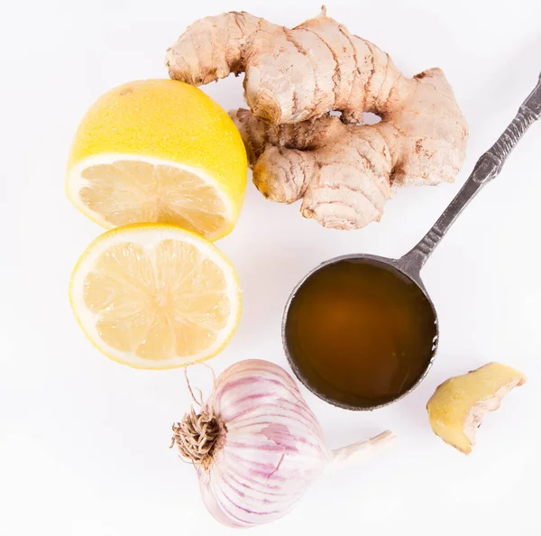 Honey, lemon, ginger and garlic on a white background