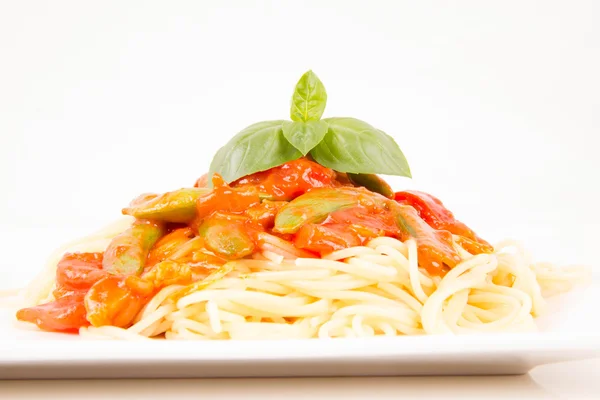 Pasta med sås på vit bakgrund — Stockfoto