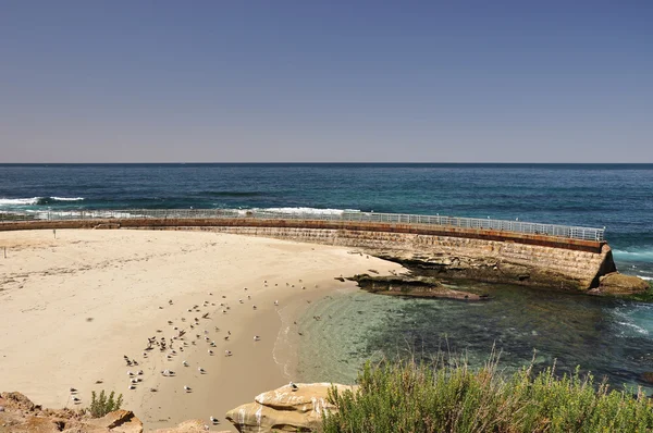 Strand mit Kinderbecken und Meeresmauer — Stockfoto