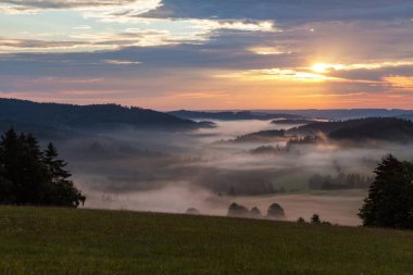 Krasne köyü yakınlarındaki Bohem ve Moravya dağlarından güzel gökyüzünün panoramik günbatımı manzarası