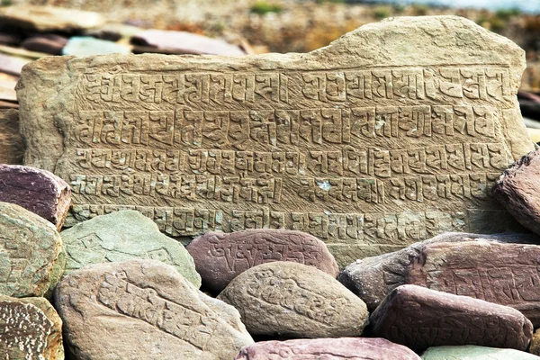 Mani wall and stones with buddhist symbols — Stock Photo, Image