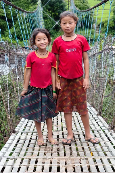 Piccole ragazze nepalesi sul ponte sospeso appeso corda — Foto Stock