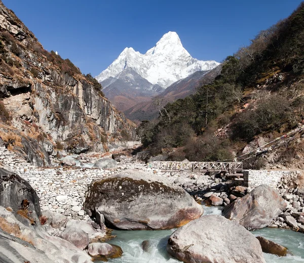 Ama Dablam con piedra y puente de madera sobre el río — Foto de Stock