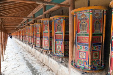 Prayer wheel around Labrang Monastery clipart