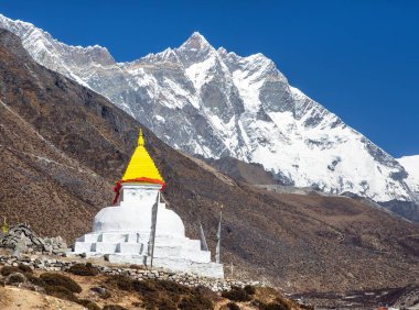 Stupa ve dua bayrakları Dingboche köyü yakınlarında Lhotse Dağı 'yla birlikte Everest ana kampına, Khumbu vadisine, Solukhumbu' ya, Sagarmatha ulusal parkına, Nepal himalayas dağlarına kadar uzanıyor.