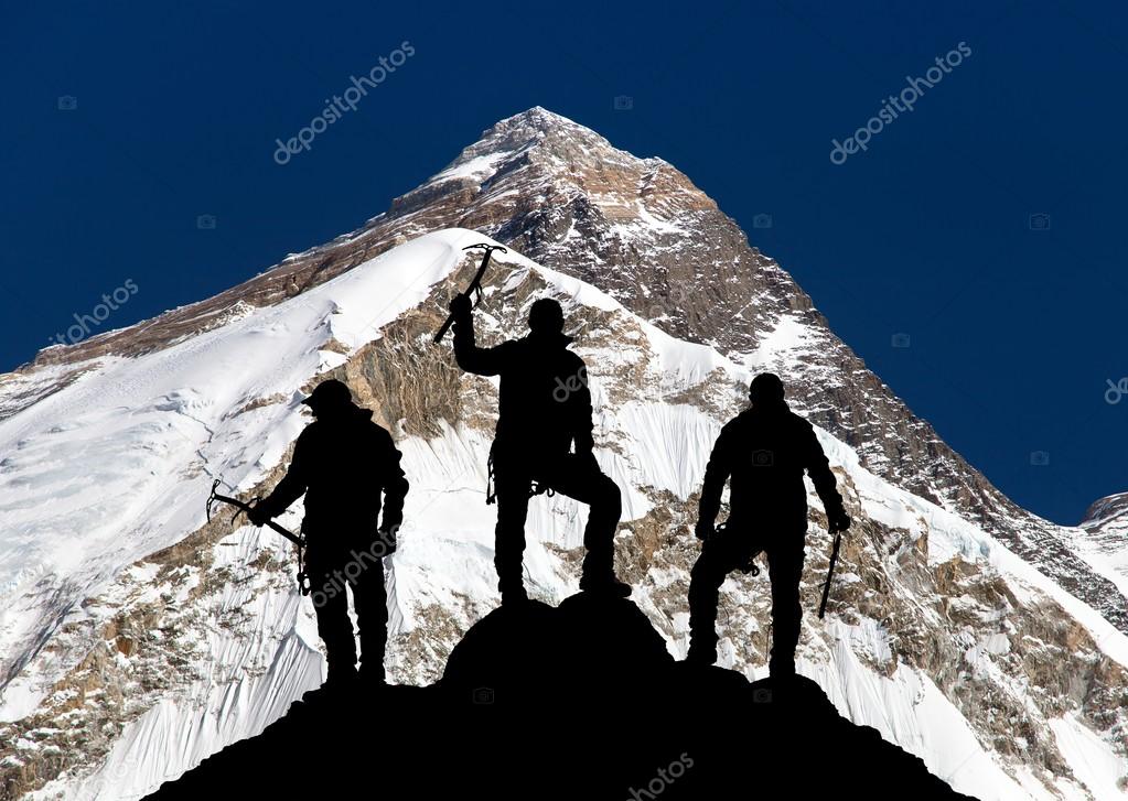 Mount Everest and silhouette of three climbers