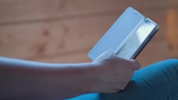 Drewnianym Domu Kobieta Niebieskich Dżinsach Stuka Ekran Smartfona Kciukiem — Wideo stockowe