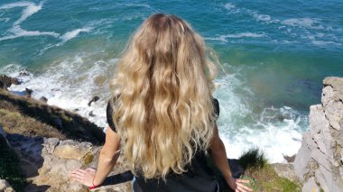 geri kayaya oturan sarışın kız