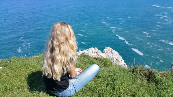 Geri kayaya oturan sarışın kız — Stok fotoğraf
