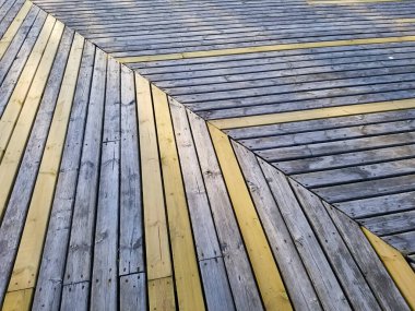 Sarı ve mavi tahtalardan yapılmış ahşap bir zemin. Plank deseni belli bir açıda.