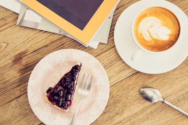 Warme koffie latte met blauwe bes kaas taart vrije levensstijl o Stockafbeelding