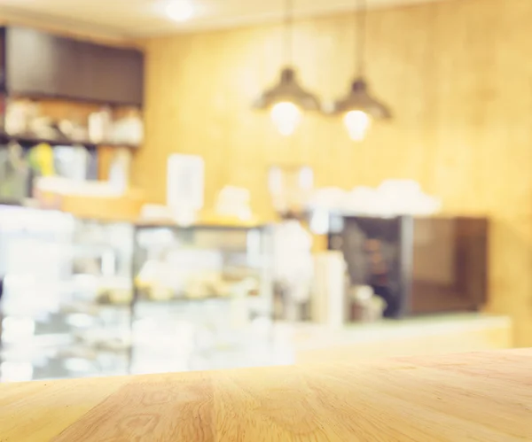 Houten tafel en onscherpte restaurant koffieshop achtergrond — Stockfoto