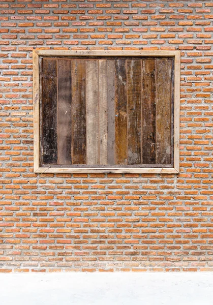 Грандиозное окно из дерева на фоне оранжевой кирпичной стены — стоковое фото
