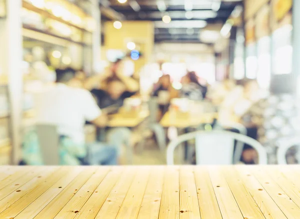 Dřevěný stůl borovice v rozostření pozadí interiér restaurace — Stock fotografie