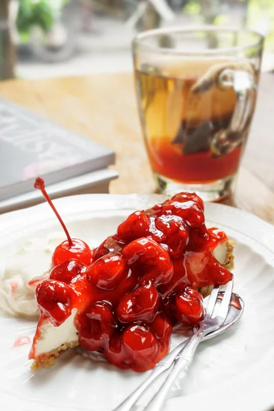 Huisgemaakte cherry Cheesecake met vruchten thee op houten tafel — Stockfoto