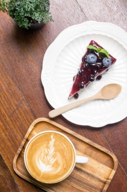 Ahşap masa mavi berry peynir pasta ve kahve latte