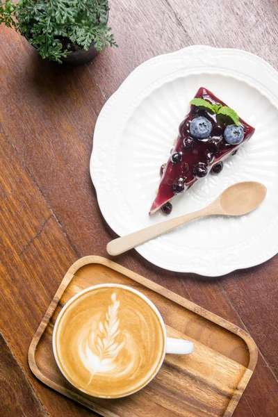 stock image Blue berry cheese cake and coffee latte on wooden desk