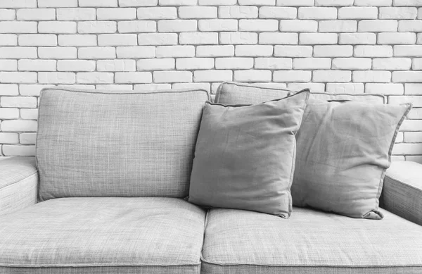 白いレンガ壁の背景にグレーのリネンのソファー ソファ椅子 — ストック写真