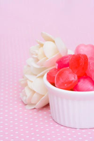 Red heart shape candy on pink tablecloth — Stock Photo, Image