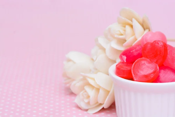 Red heart shape candy on pink tablecloth — Stock Photo, Image