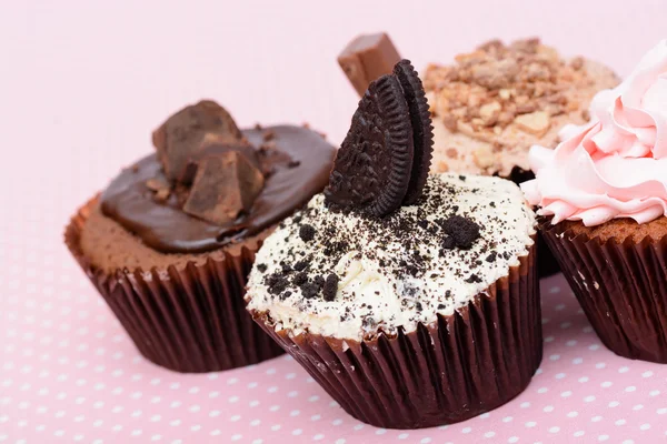 Bolinhos de morango de chocolate e bolo de xícara de creme na toalha de mesa rosa vintage — Fotografia de Stock