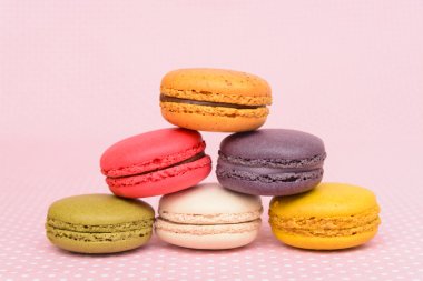 Pembe vintage masa örtüsü üzerinde renkli acıbadem kurabiyesi