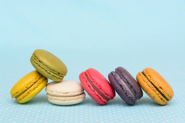 Mavi vintage masa örtüsü üzerinde renkli acıbadem kurabiyesi