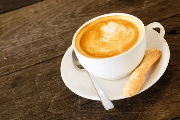 Latte art coffee on wooden table — Stock Photo, Image