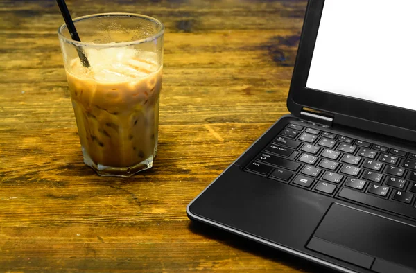 Café gelado na mesa de madeira com um notebook de computador — Fotografia de Stock