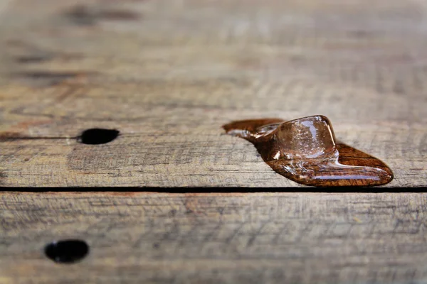 Cubo de gelo derretendo na mesa de madeira — Fotografia de Stock
