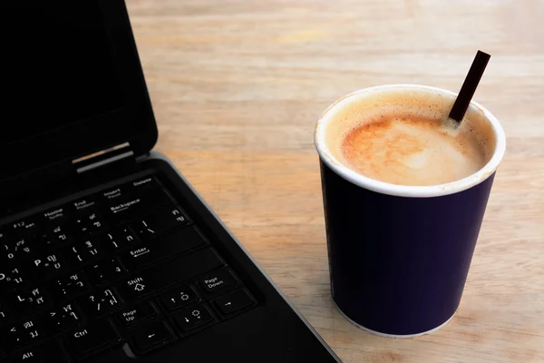 Hot latte coffee paper cup with computer notebook — Stock Photo, Image