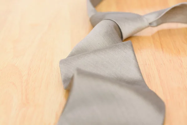 Silver necktie on wooden table background — Stock Photo, Image