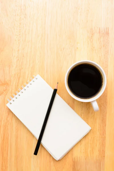 Caffè nero e blocco note su tavolo in legno — Foto Stock