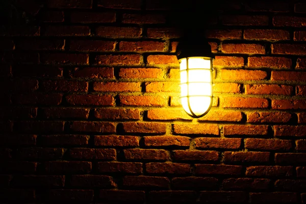 Лампочка на старовинній оранжевій цегляній стіні — стокове фото