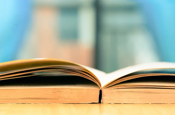 Vintage book on wooden table beside window — Stock Photo, Image