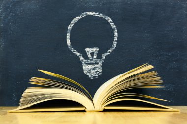 Vintage eski kitap yazı tahtası arka plan üzerinde yukarıda ampul simgesi