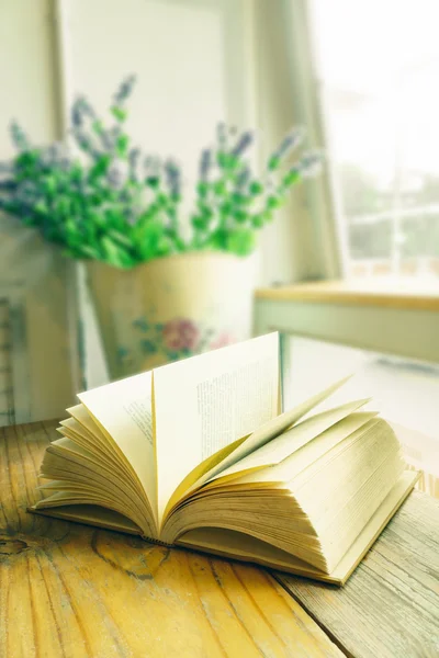 Vintage book on wooden table beside window — Stock Photo, Image