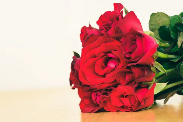 Rudá růže na dřevěný stůl — Stock fotografie