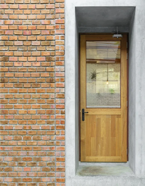Ancienne entrée de porte en bois sur mur de briques marron orangé — Photo