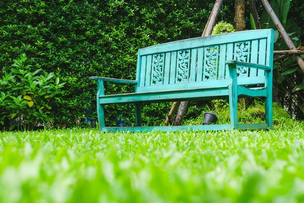 Vintage bench in grass garden from low angle shot — Stock Photo, Image