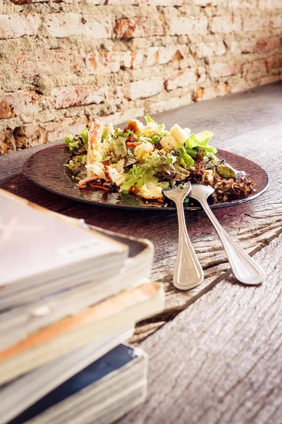 Salada Caesar em mesa de madeira grunge e parede de tijolo — Fotografia de Stock