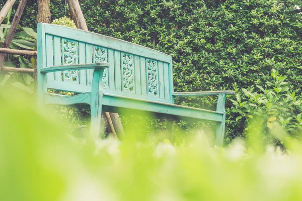 Vintage bench in grass garden from low angle shot — Stock Photo, Image