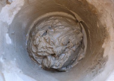 Üst görünüm çimento sıvısı eski kovada karıştırılmaya hazır. İnşaat için el işi aleti. Seçici odak