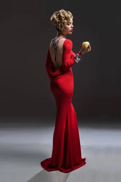 Frau im roten Kleid mit Apfel — Stockfoto